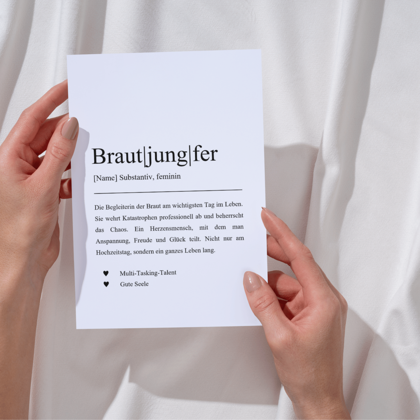 Definition der Brautjungfer als humorvolle Karte, die ihre Rolle bei Hochzeiten beschreibt. Zwei Hände halten die Karte vor einem weißen Hintergrund. Perfekte Geschenkidee für Junggesellinnenabschiede und um Dankbarkeit auszudrücken.