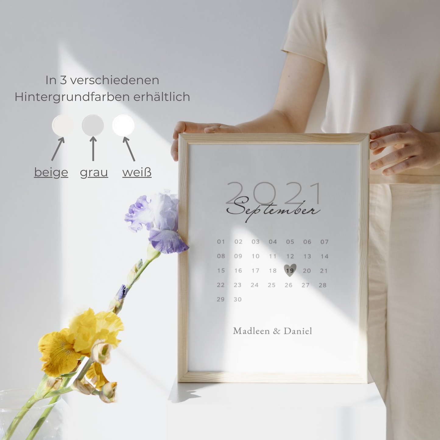 Personalisierter Kalender im Holzrahmen mit dem Namen Madleen und Daniel. Verfügbar in beige, grau und weiß. Perfekte personalisierbare Wanddekoration für besondere Anlässe mit floralen Elementen.