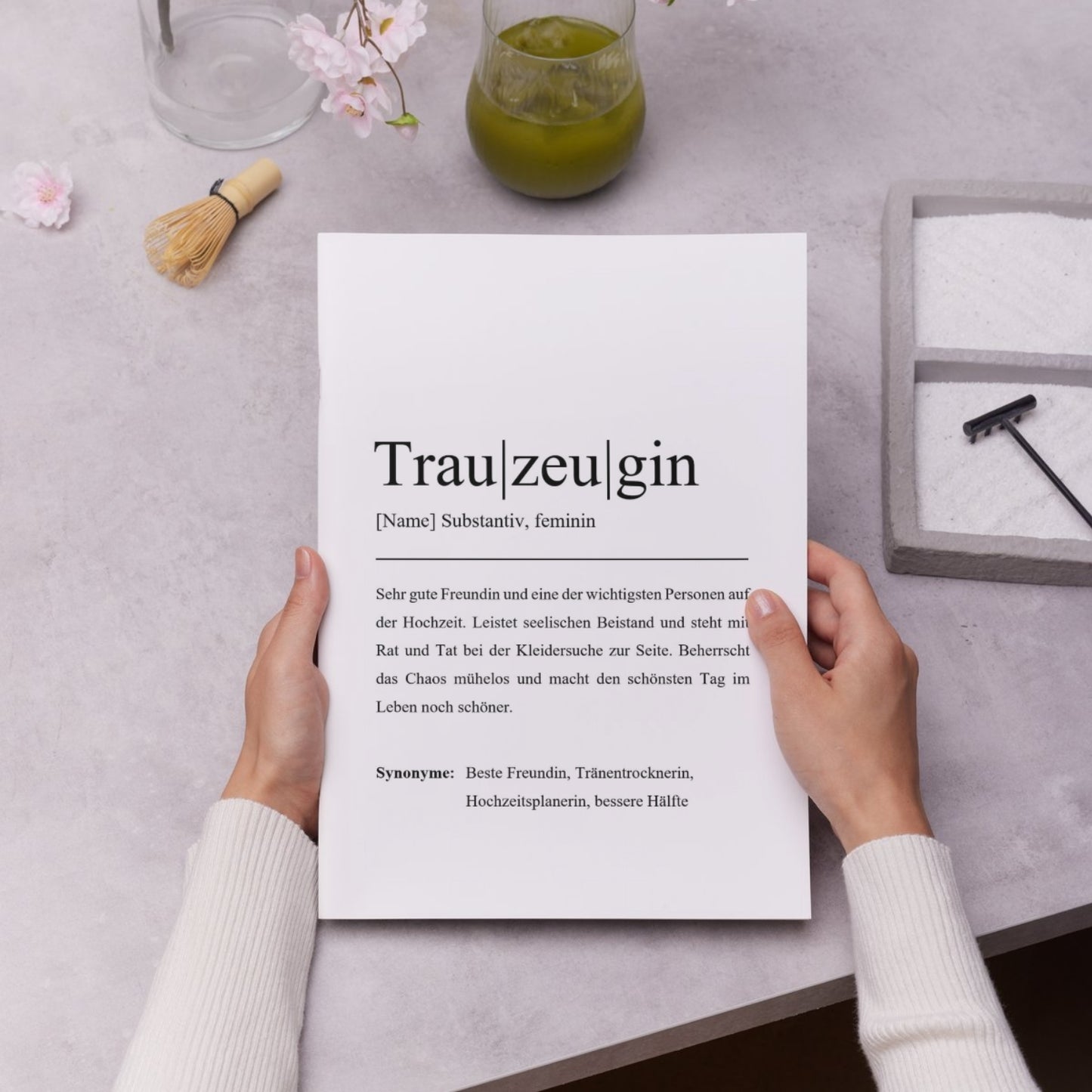 Eine Person hält ein personalisierbares Trauzeuginnen-Poster in den Händen, umgeben von stilvollen Accessoires. Ideal zur Personalisierung und als besonderes Hochzeitsgeschenk.