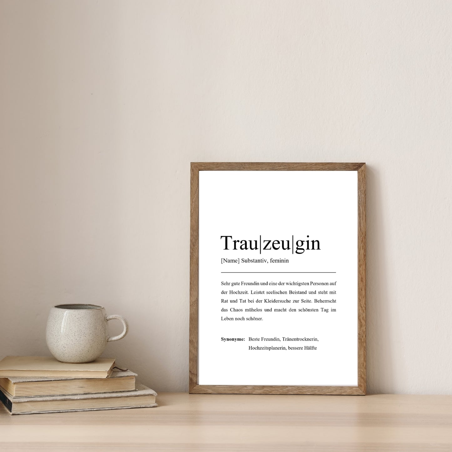 Trauzeuginnen-Poster im rustikalen Holzrahmen, auf einem Tisch neben Büchern und einem Keramikbecher. Stilvolles und individuelles Hochzeitsgeschenk.